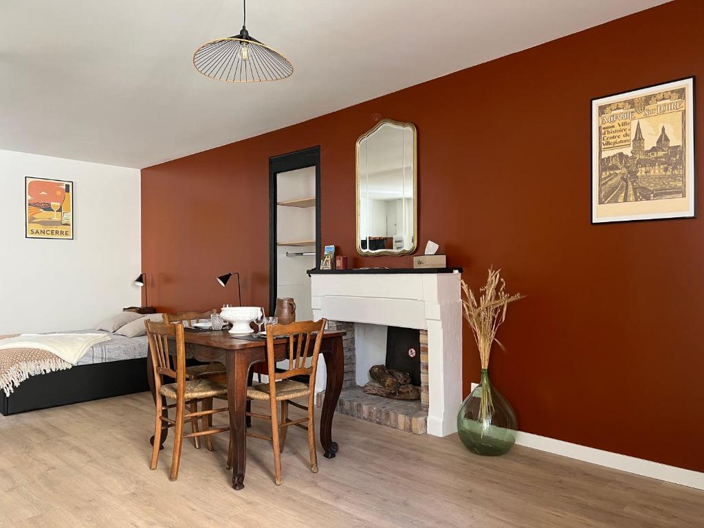 a dining room with a table and a fireplace at L’Etape, cœur de ville in La Charité-sur-Loire