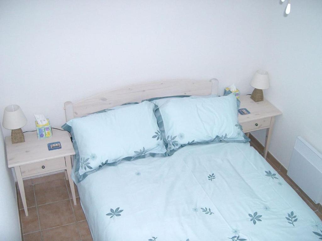 グリモーにあるles grimaudieresのベッドルーム1室(青いシーツと枕のベッド1台付)