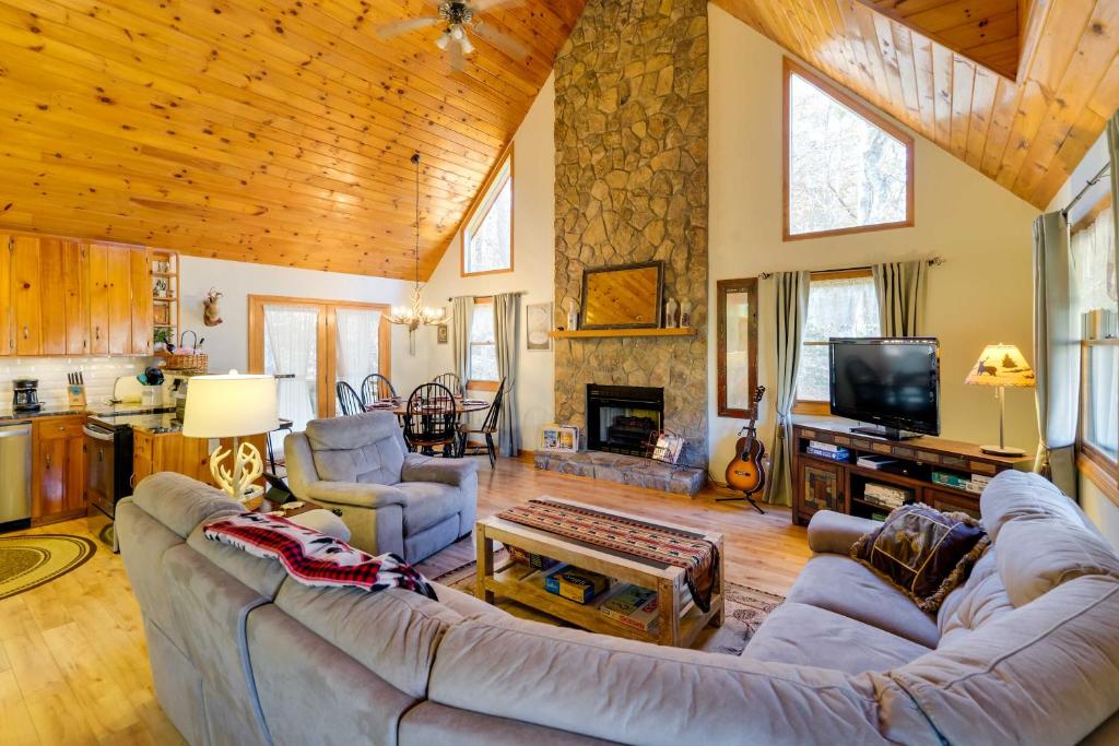 a large living room with a couch and a tv at Smoky Mountain Cabin with Fire Pit Hike and Fish! in Murphy