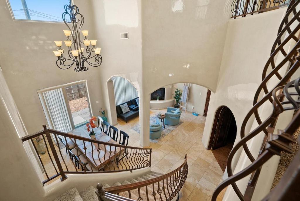 a spiral staircase in a living room with a chandelier at Luxury Tuscan Villa Near Old Town in Albuquerque