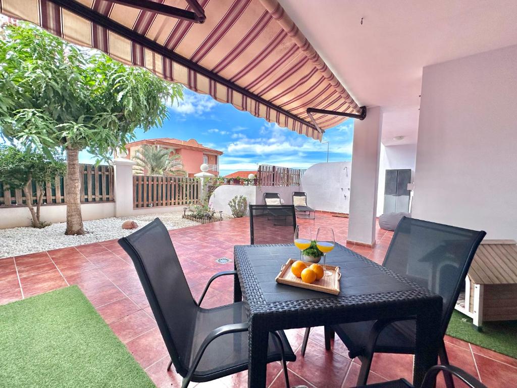 una mesa negra y sillas en un patio con mesa y fruta en Terracita de Luces, en La Laguna