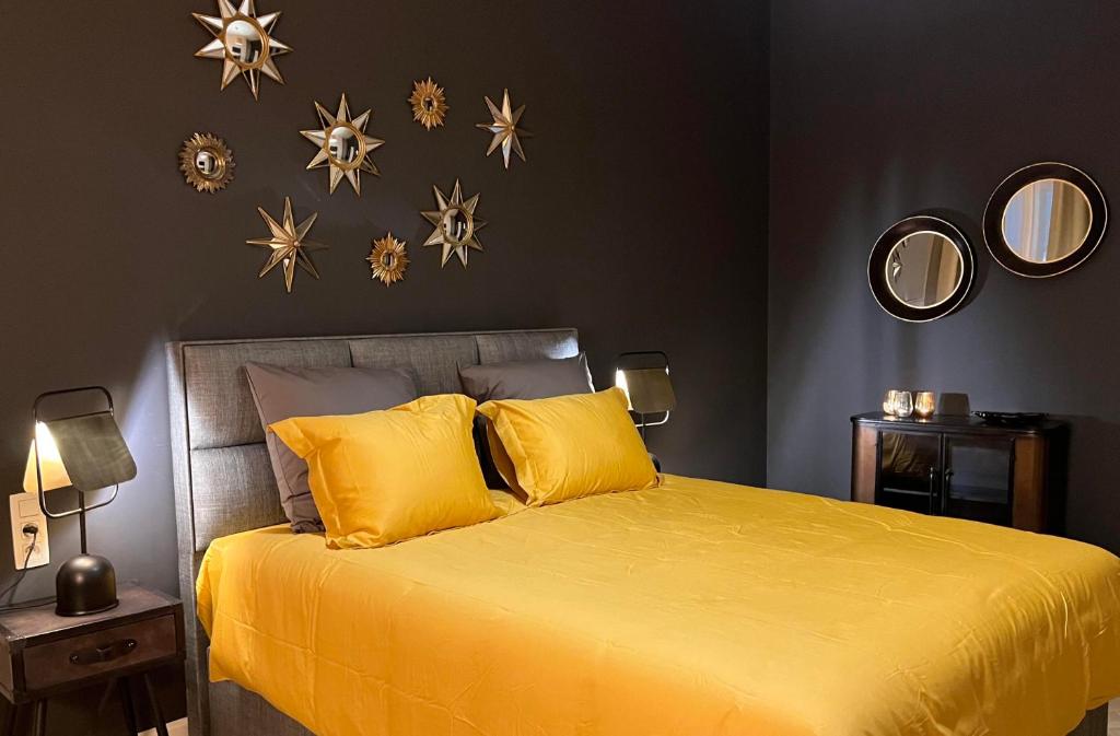 a bedroom with a yellow bed with stars on the wall at Le Vieux Cèdre Grand Place in Mons
