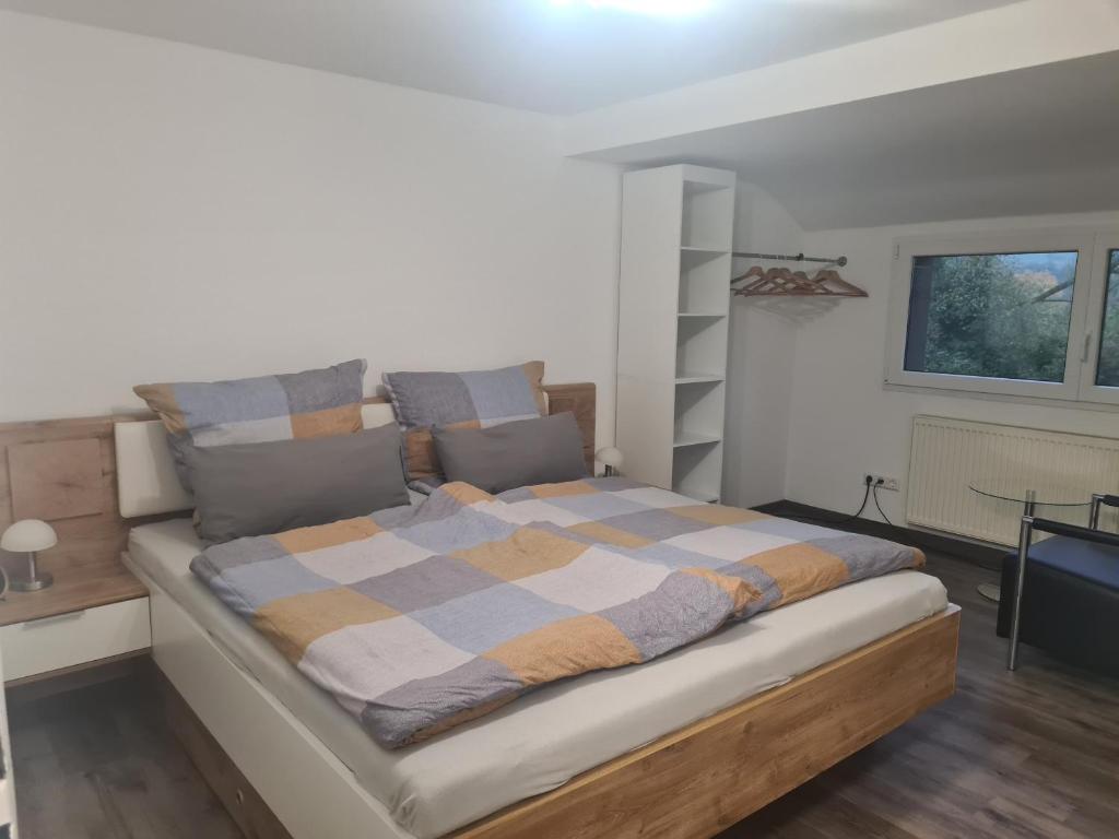 een slaapkamer met een groot bed en een geruite deken bij Wohnung mit 2 Schlafzimmern in Wutöschingen