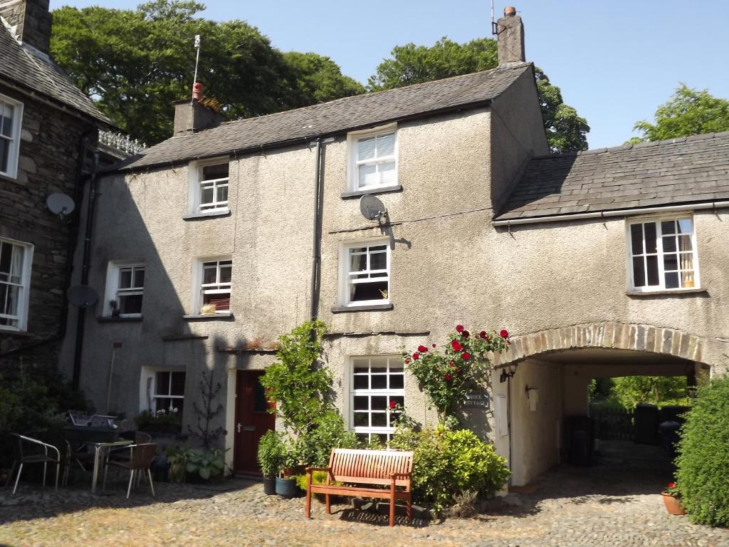 an old house with an archway in front of it at 18th Century character cottage, Broughton-in-Furness in Broughton in Furness