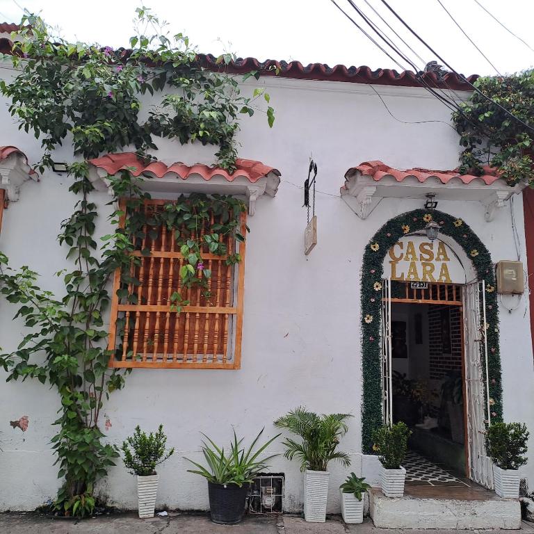 a white building with a sign that reads casa jaza at Hostal Casa Lara in Cartagena de Indias