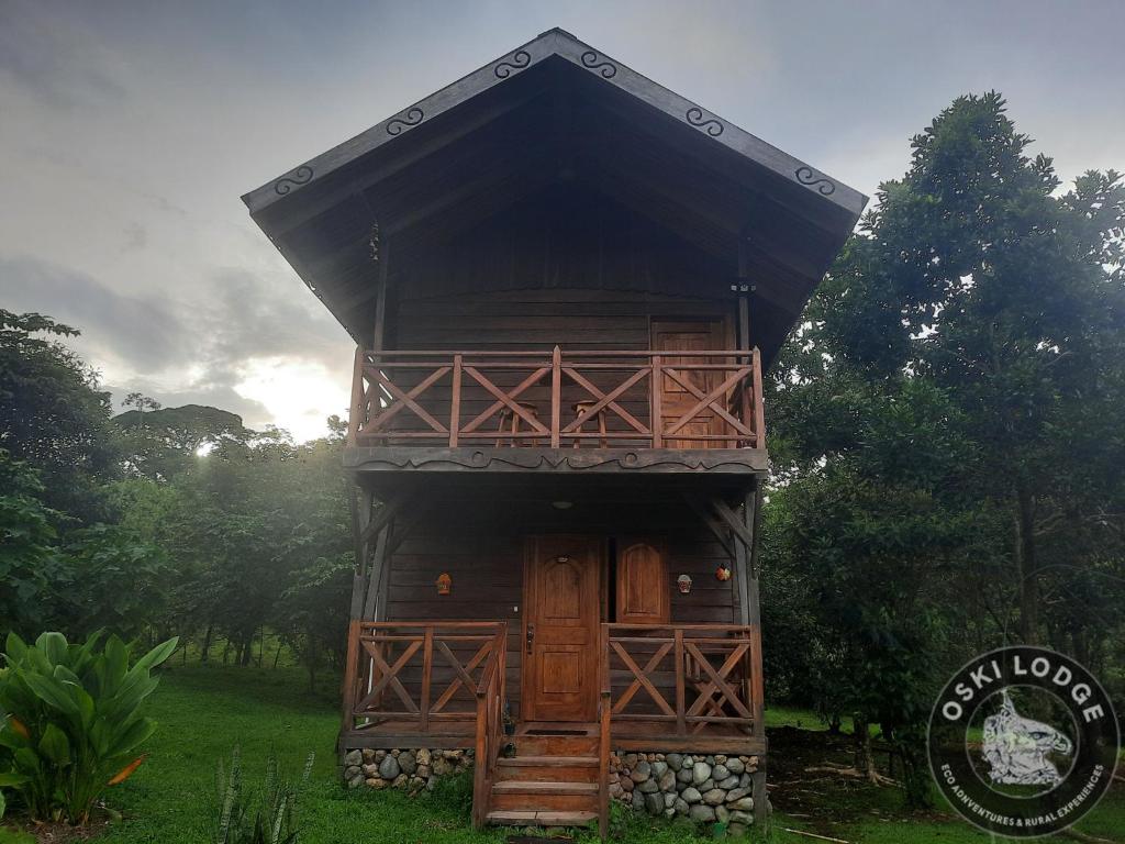 a tree house in a field with a sign at Oski Lodge, Rain Forest Rincón de la Vieja in Upala