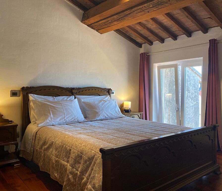 a bedroom with a bed with white pillows and a window at TUSCANY LOFT IN THE CITY in Livorno