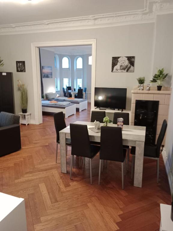 een woonkamer met een tafel en stoelen en een open haard bij Flensburg Zentrum 1 3 M R in Flensburg