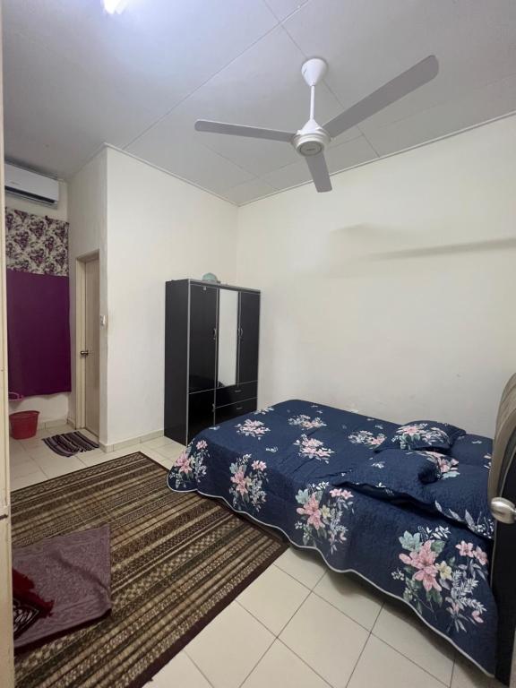 um quarto com uma cama e uma ventoinha de tecto em Mama Homestay em Kampong Jubakar Pantai