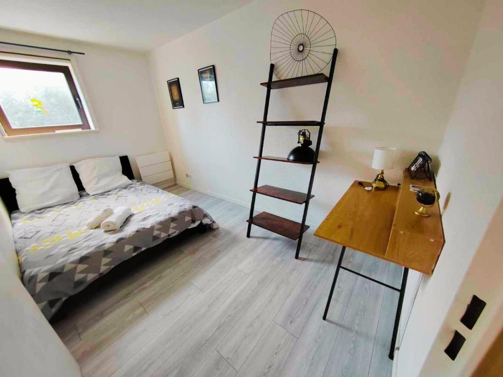 - une chambre avec un lit et une table en bois dans l'établissement T2 - au coeur de la roche, à La Roche-sur-Yon
