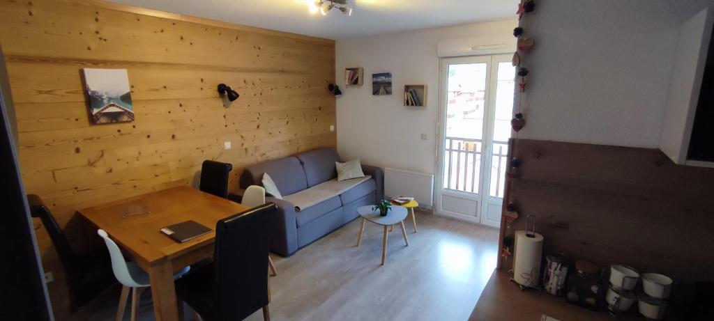 a living room with a blue couch and a table at Joli T2 + coin montagne + Garage in Briançon