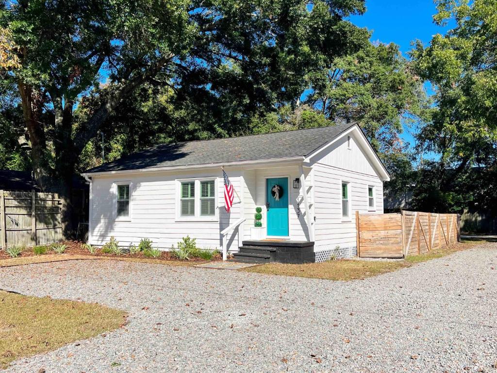 une petite maison blanche avec un drapeau devant elle dans l'établissement Coastal Bungalow - NEW 2 Bedrooms - Mt Pleasant, à Charleston