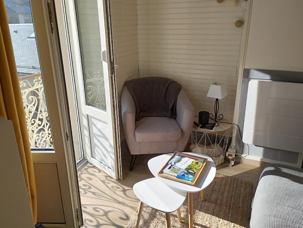 une chambre avec une chaise et une table avec une tablette dans l'établissement appartement cosy hyper centre de Cauterets, à Cauterets