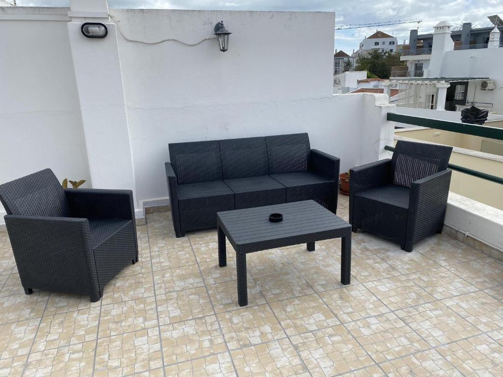 2 sillas, sofá y mesa en el balcón en Tavira sweet home, en Tavira
