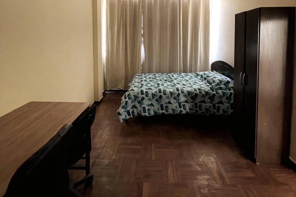 Schlafzimmer mit einem Bett und Holzboden in der Unterkunft Departamento con vista a la Plaza in Cajamarca