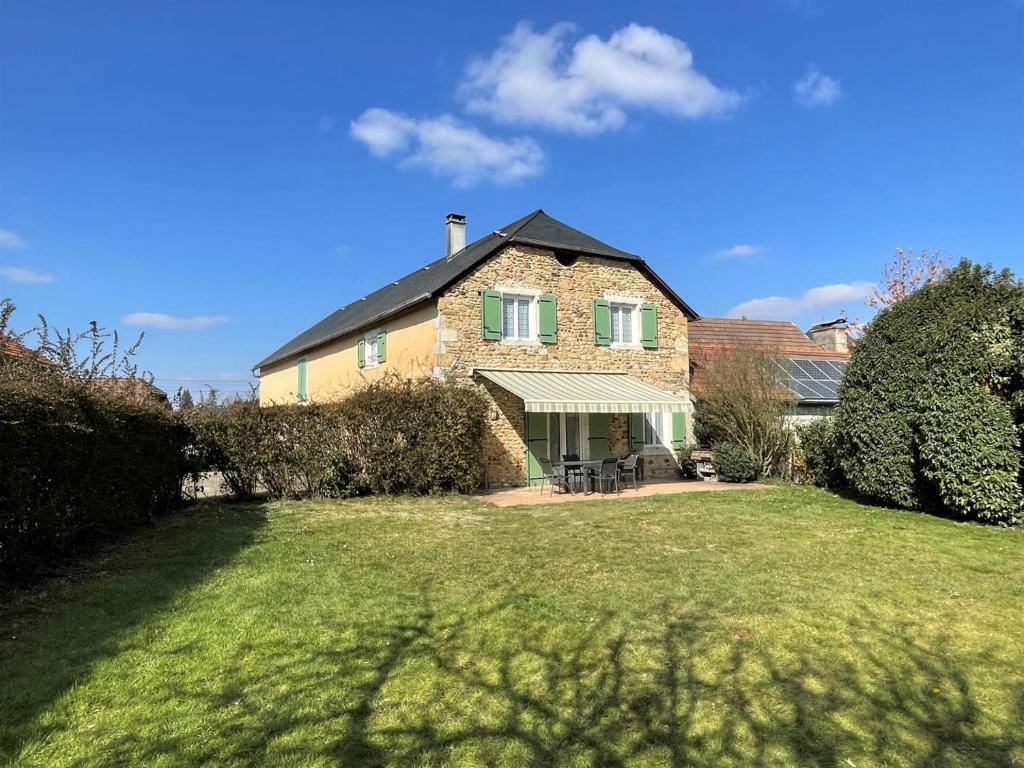 a large brick house with a grass yard at Chez evon in Jurançon