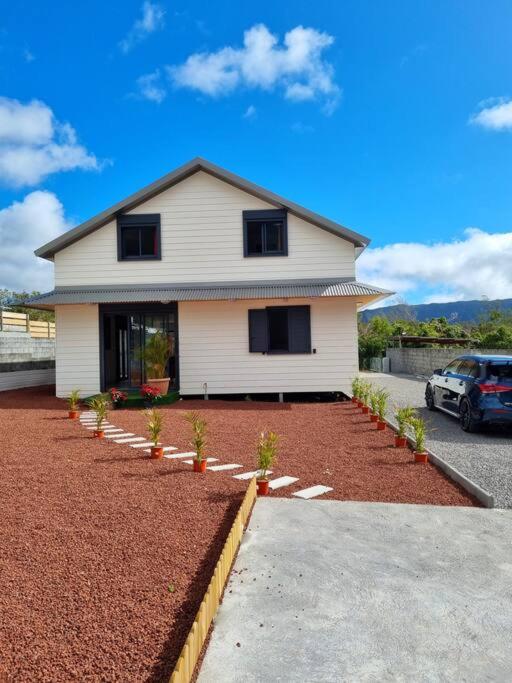 a white house with a car parked in front of it at Villa Piton Textor in La Plaine des Palmistes