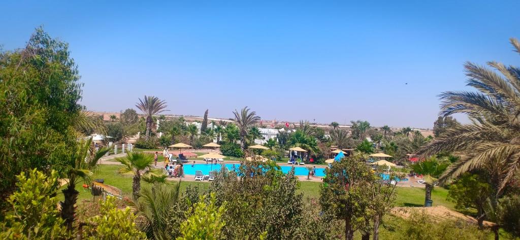 vista su un resort con piscina e palme di Camping la palmeraie Tifnit a Tifnit