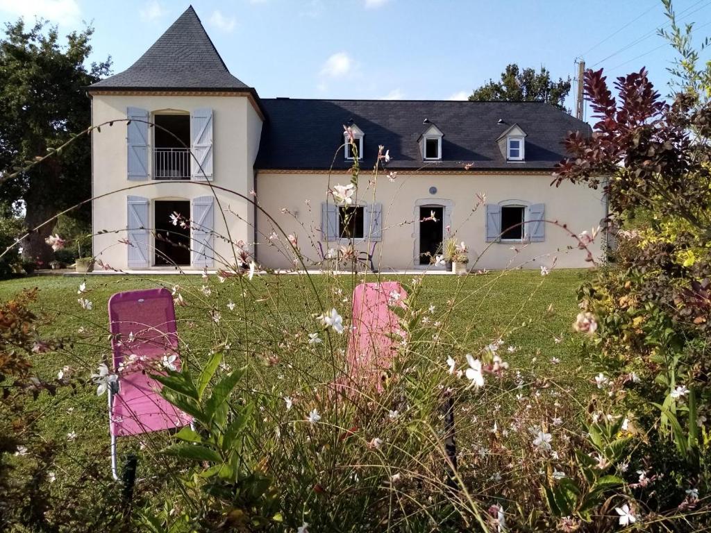 een groot wit huis met een zwart dak bij Brecat in Saint-Faust