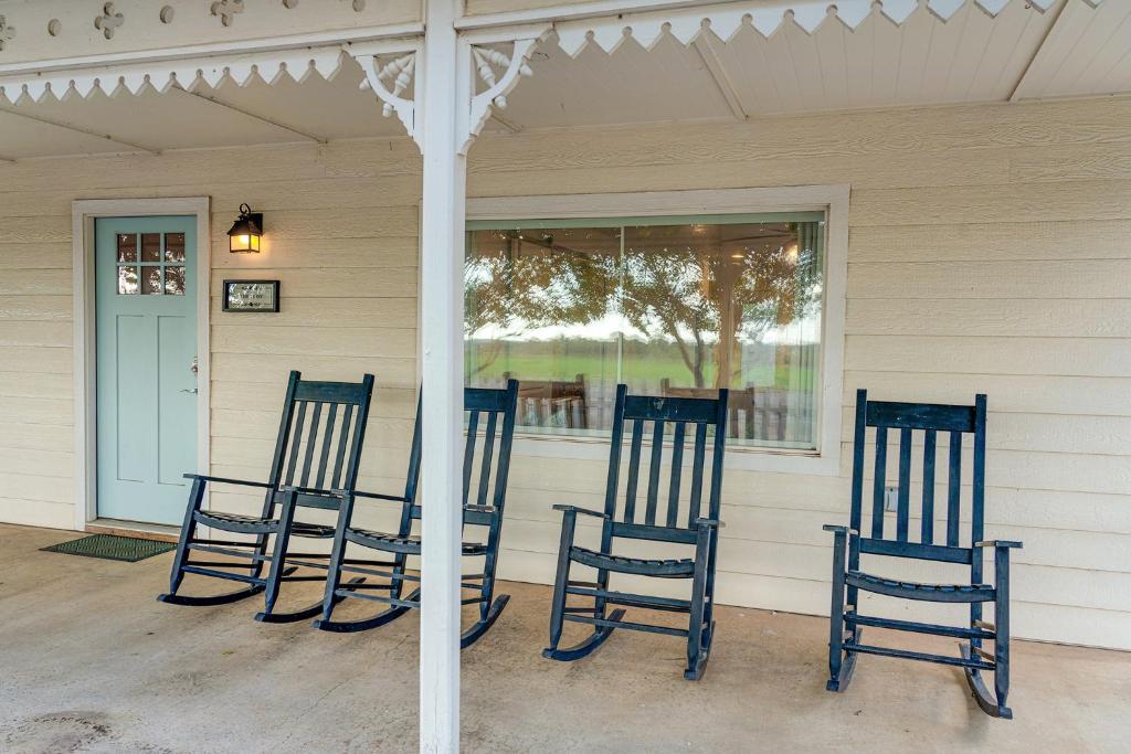 drie blauwe stoelen op de veranda van een huis bij The Judy in Harper