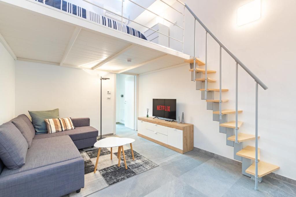 salon z kanapą i schodami w obiekcie Exclusive Loft Crocetta - Free Private Parking & Wi-Fi - 5 min To Metro Nizza w Turynie