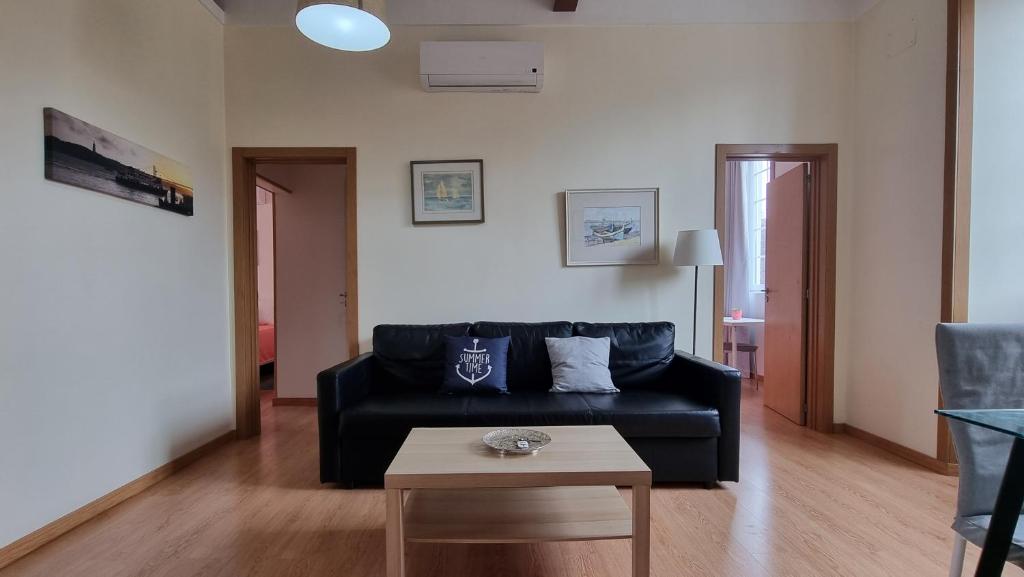 奧埃拉什的住宿－Oeiras 4，客厅配有黑色沙发和桌子