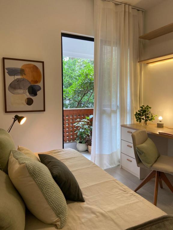 1 dormitorio con cama, escritorio y ventana en Lagoa relax en Río de Janeiro