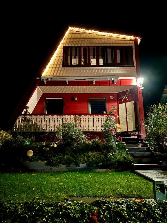 una casa roja con luces en el costado. en Ferienhaus Veronika Odenwald, en Brensbach