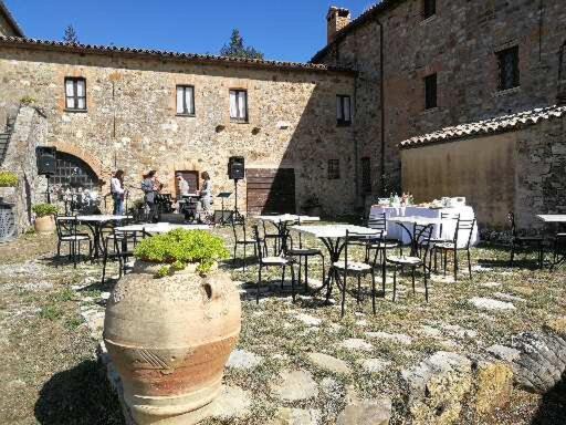 een groep tafels en stoelen voor een gebouw bij Agriturismo L'Elmo in Bagni