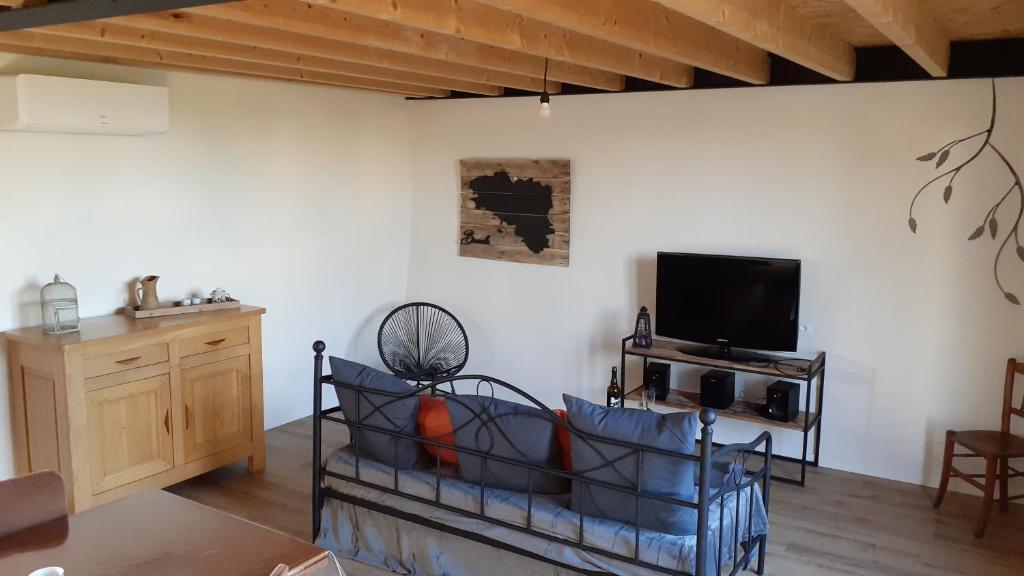 ein Wohnzimmer mit einem Sofa und einem TV in der Unterkunft Le Ty Douar in Coëtmieux