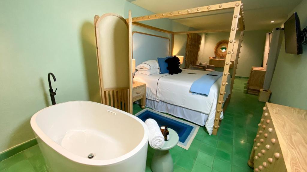 łazienka z wanną i sypialnia z łóżkiem w obiekcie William Hotel Boutique De Diseño w mieście Taxco de Alarcón