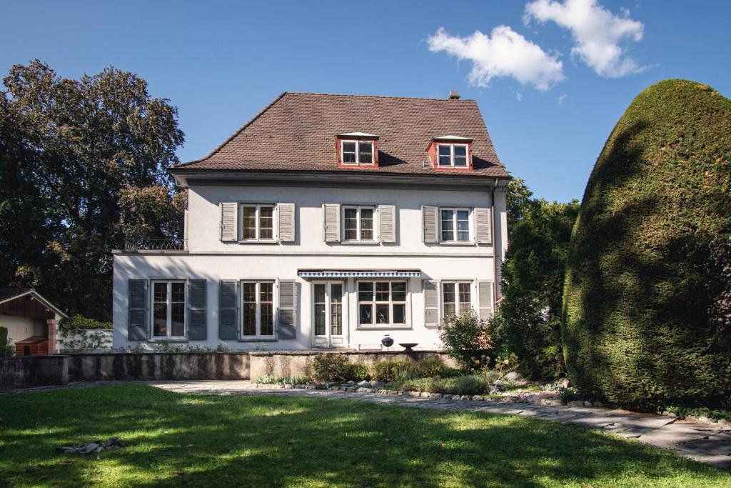 a white house with a gambrel roof at Beautiful Villa in the Heart of Basel in Basel