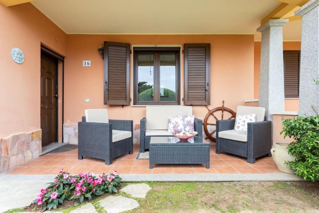 un patio con sillas, una mesa y una ventana en [2 KM DAL MARE] Villetta relax con barbecue, en Palmadula