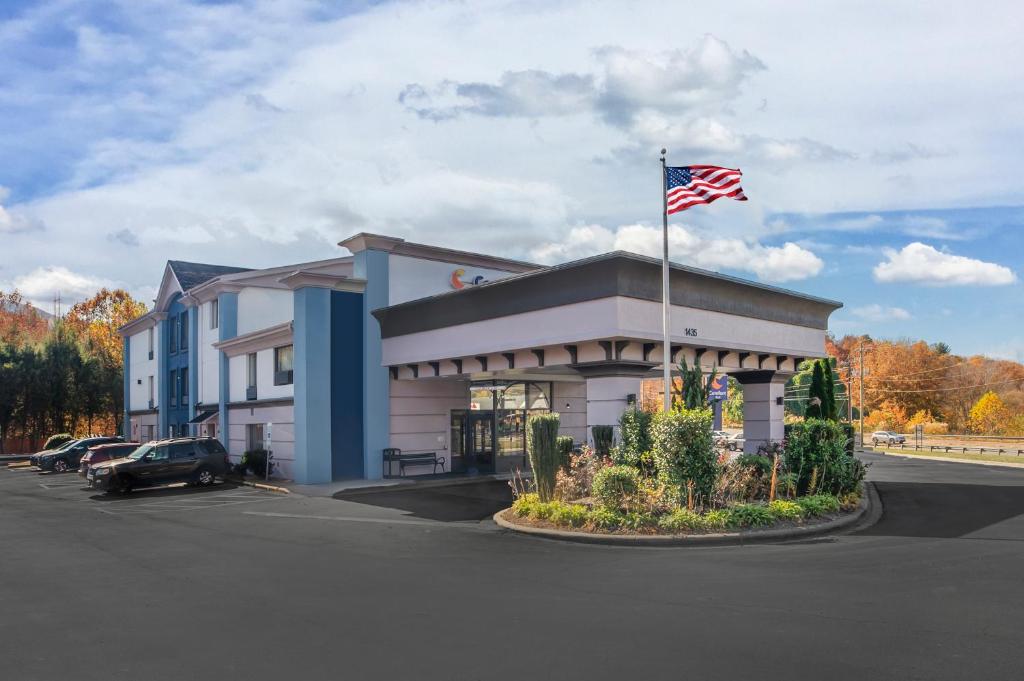 un edificio con una bandera americana en un estacionamiento en Comfort Inn Asheville East-Blue Ridge Pkwy Access en Asheville