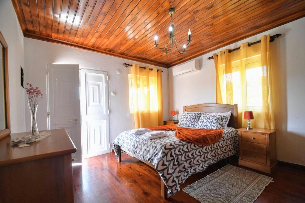 a bedroom with a bed and a wooden ceiling at Casa da Avó in Ponte de Lima