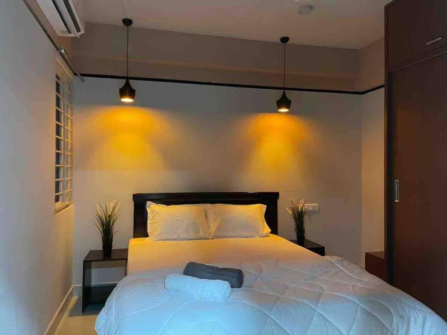 a bedroom with a large white bed with two pillows at Apricot: 1bhk Humble Abode in Botanical Gardens in Hyderabad