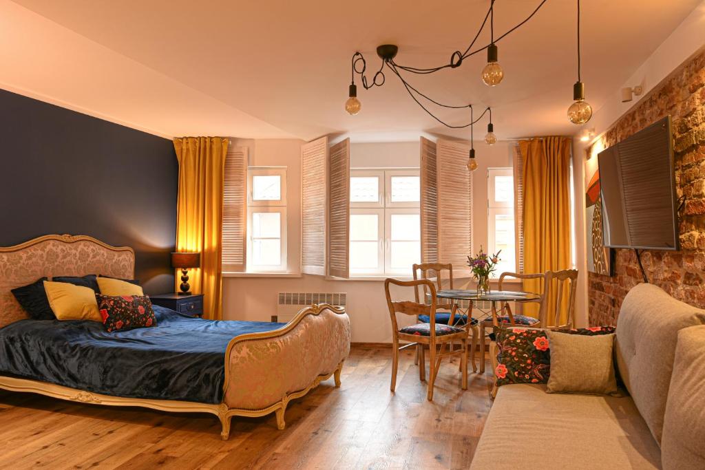 a bedroom with a bed and a dining room at GOTHIC COLORS in Toruń