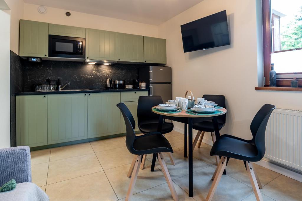 カルパチにあるApartament Przy Szlaku, bezpłatny parkingの部屋にテーブルと椅子のあるキッチン