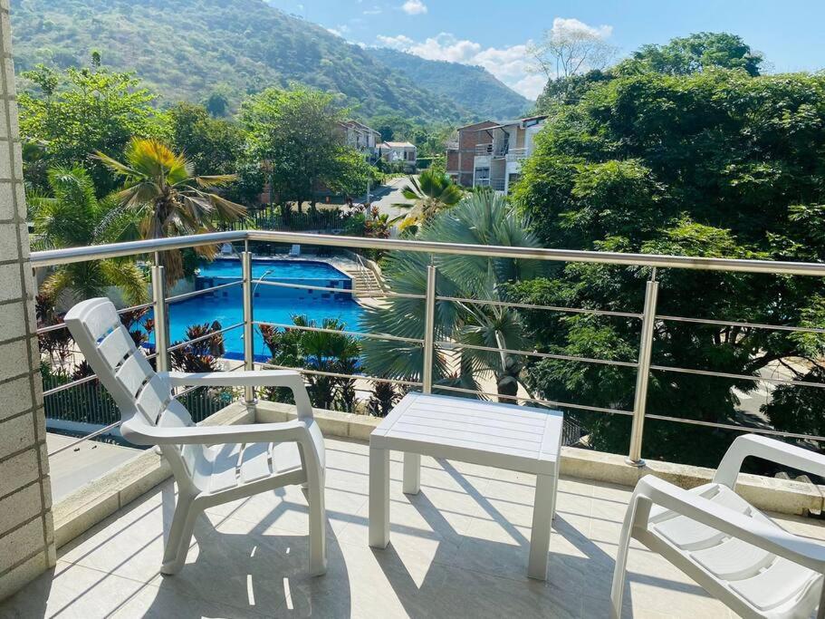 un patio con 2 sillas y una mesa en el balcón en Casa de verano en Sopetrán en Sopetran