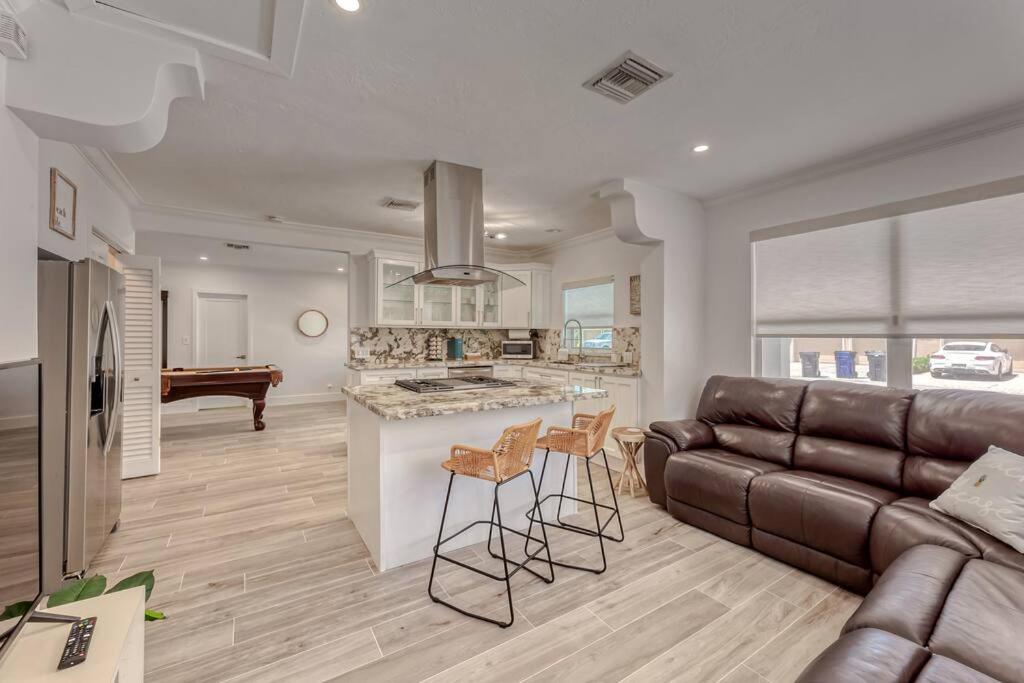 a kitchen and living room with a couch and a table at Mango Manor - Walk to Las Olas! in Fort Lauderdale
