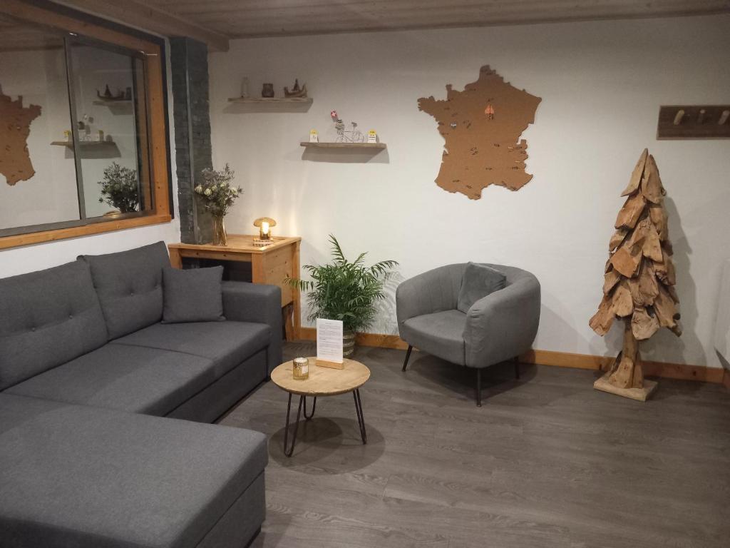 a living room with a couch and a chair and a christmas tree at Les Hauts de Sallanches in Sallanches