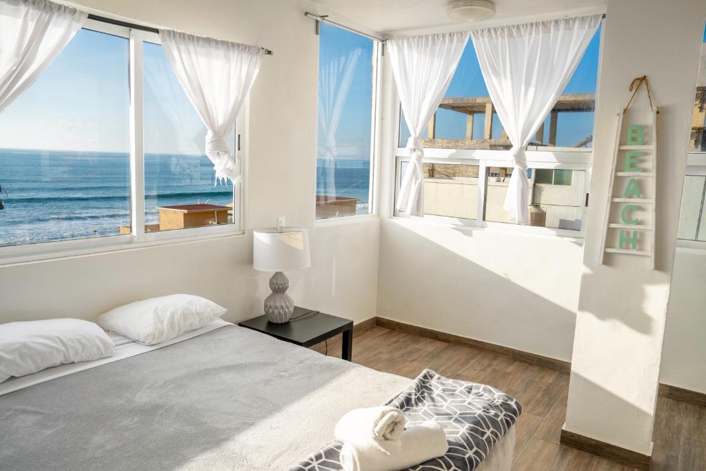 a bedroom with a bed and a view of the ocean at Ocean-VIEW Two Story Condo on the beach in Tijuana
