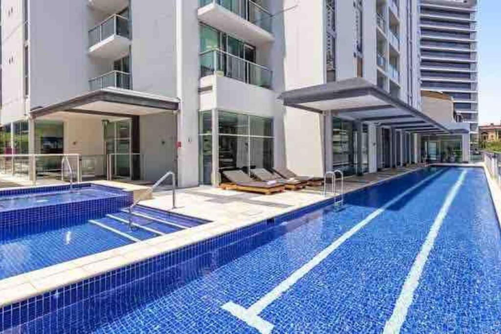 a swimming pool in front of a building at Prime location - CBD Brisbane 1 bed w shared 25m pool, gym, sundeck and a BBQ area in Brisbane