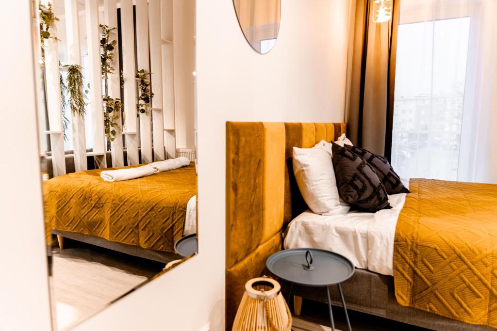 戈萊紐夫的住宿－Hop & Lulu Premium Apartments，一间卧室设有两张床、一张桌子和一个窗口