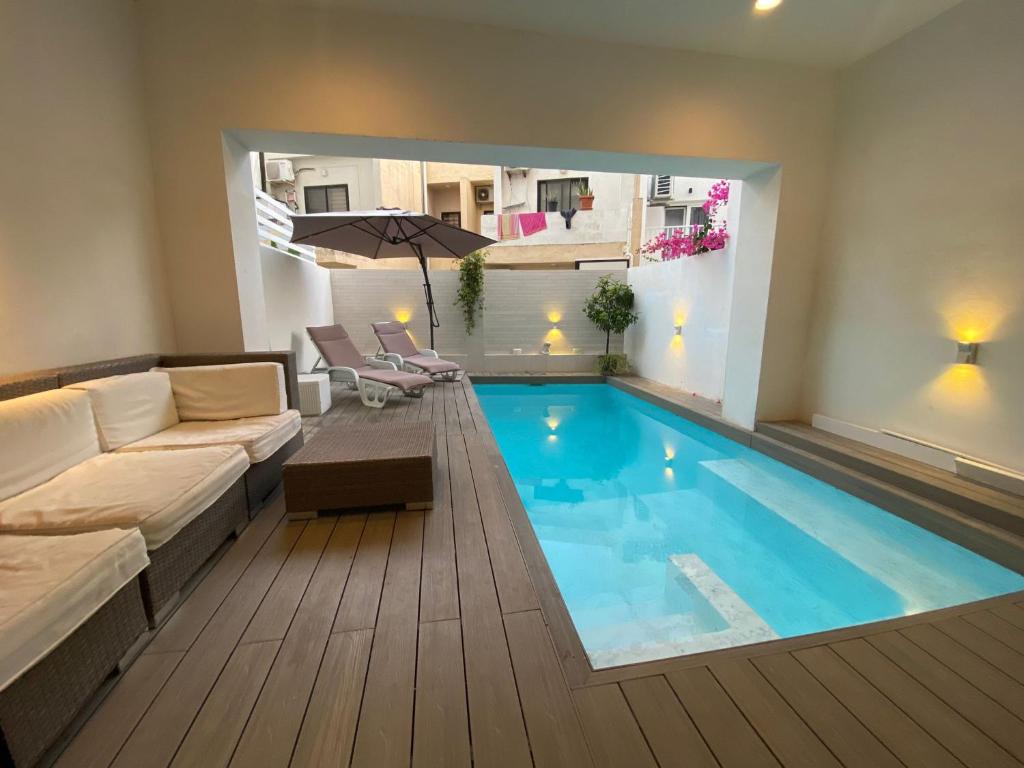 un salon avec une grande piscine dans l'établissement St Julians Apt with Pool, à San Ġiljan