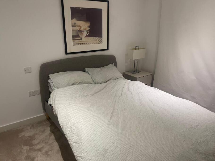 a bed in a bedroom with a picture on the wall at Stunning 2 Bedroom Apartment in London