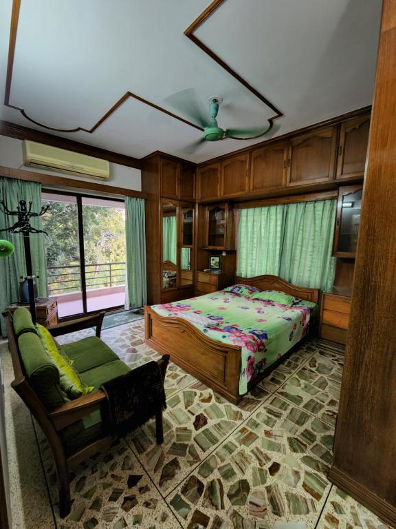 a bedroom with a bed and a couch and a chair at Dhanmondi Furnished Lake View Apartment in Dhaka