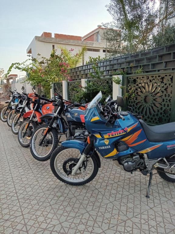 eine Reihe von Motorrädern, die neben einem Gebäude geparkt sind in der Unterkunft Riad Passiflora in Fès