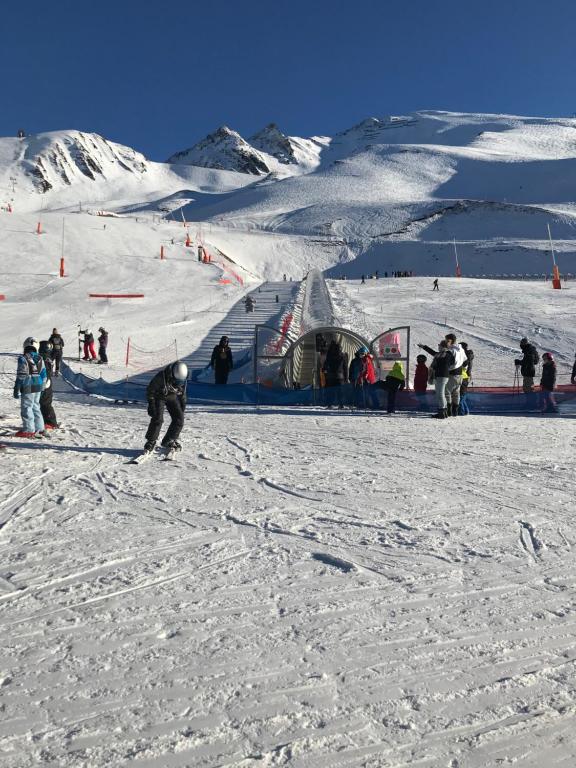 Appartement Station de ski - Les Agudes - 6 pers في Gouaux-de-Larboust: مجموعة من الناس يتزحلق على منحدر مغطى بالثلج