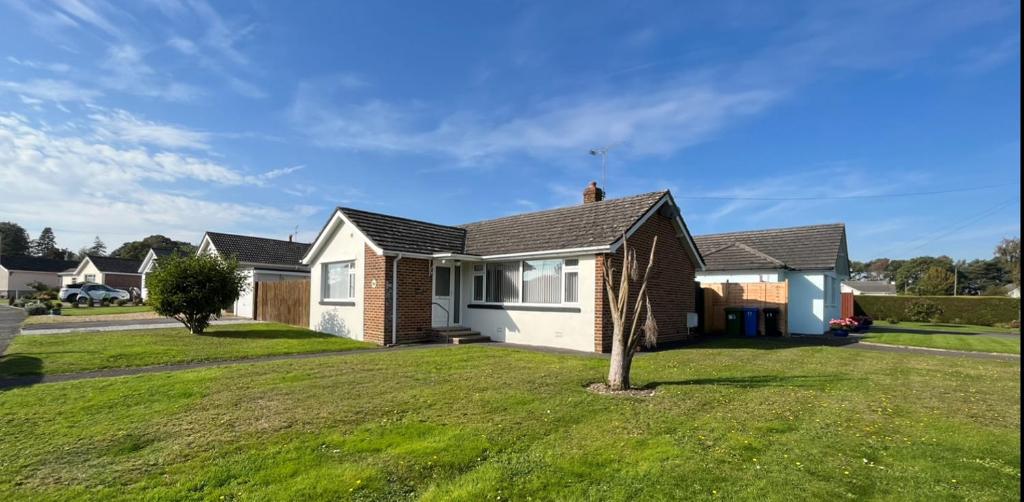 a house with a green lawn in front of it at 17 Banstead Road in Poole